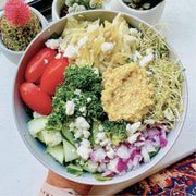 Big salad bowl with onions, kale, tomatoes, sprouts, cucumbers, feta cheese and lupini dip